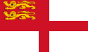 Drapeau de Sark : une croix rouge sur fond blanc, le quart supérieur droit étant occupé par les lions normands, jaunes sur fond rouge